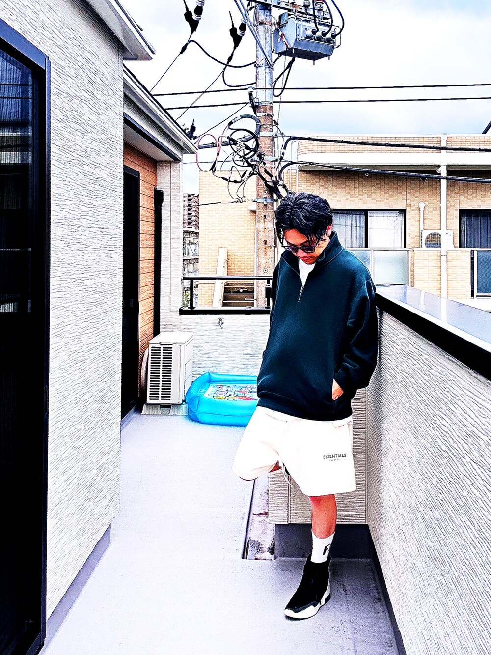 グリーン系のスウェット、ホワイト系のスウェットパンツ、ブラック系のスニーカーを着用したメンズの秋コーディネートの4枚目の写真