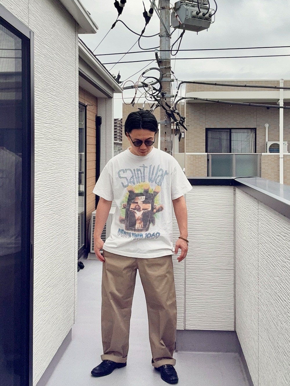 ブラック系のローファー、ホワイト系のTシャツ/カットソー、ベージュ系のチノパンツを着用したメンズの夏コーディネートの2枚目の写真