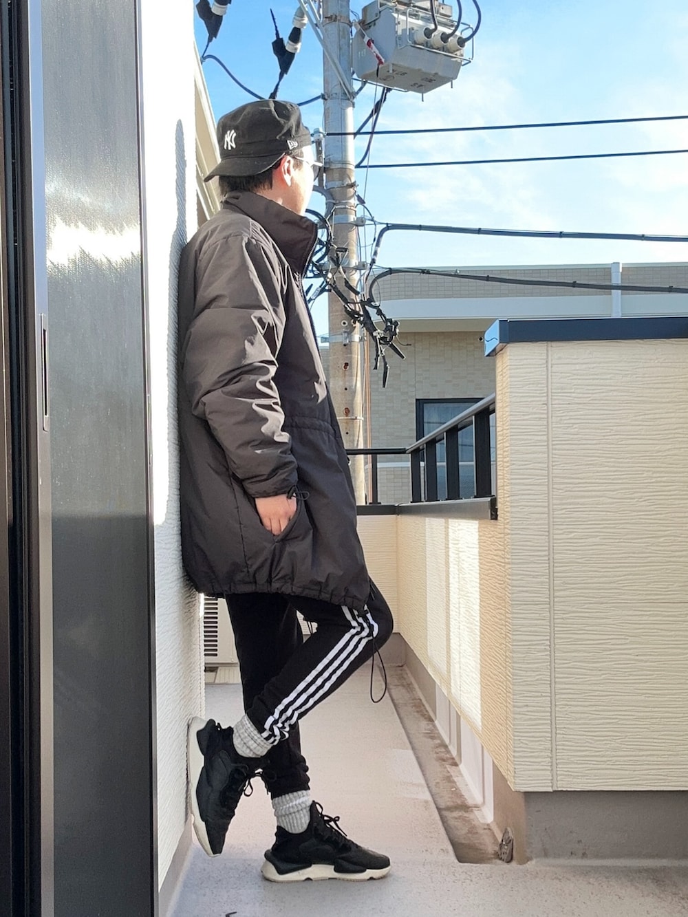 ブラック系のスウェット、ブラック系のスウェットパンツ、ブラック系のスニーカーを着用したメンズの冬コーディネートの3枚目の写真