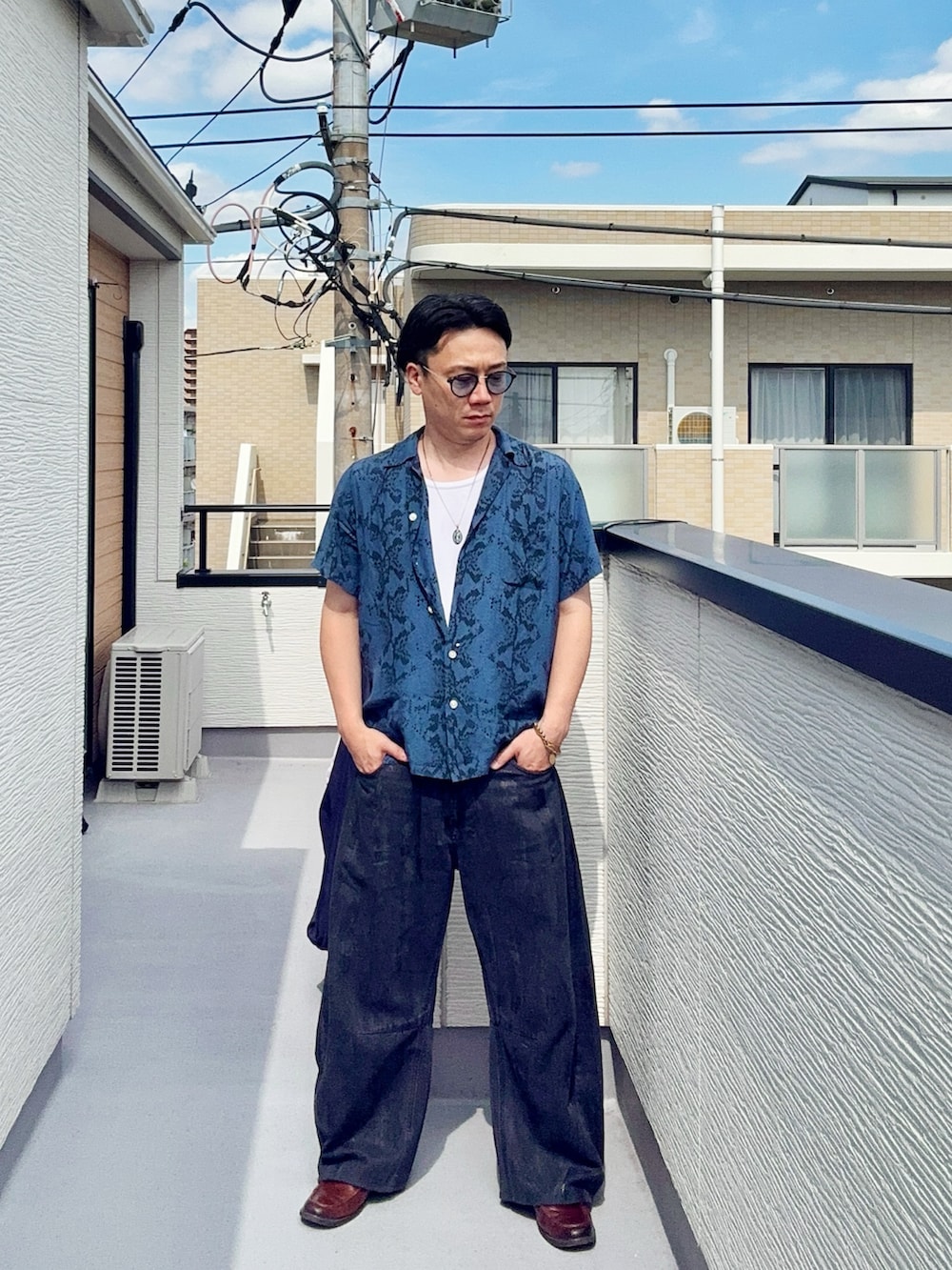 ブラック系のデニムパンツ、ブルー系のシャツ/ブラウス、ブラウン系のローファーを着用したメンズの夏コーディネートの4枚目の写真