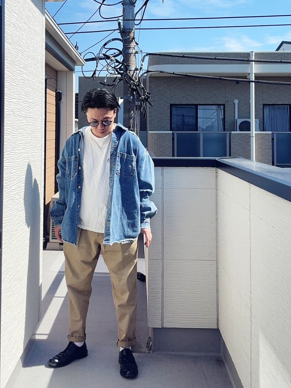 グリーン系のチノパンツ、ホワイト系のTシャツ/カットソー、ブルー系のデニムジャケットを着用したメンズの春コーディネートの2枚目の写真