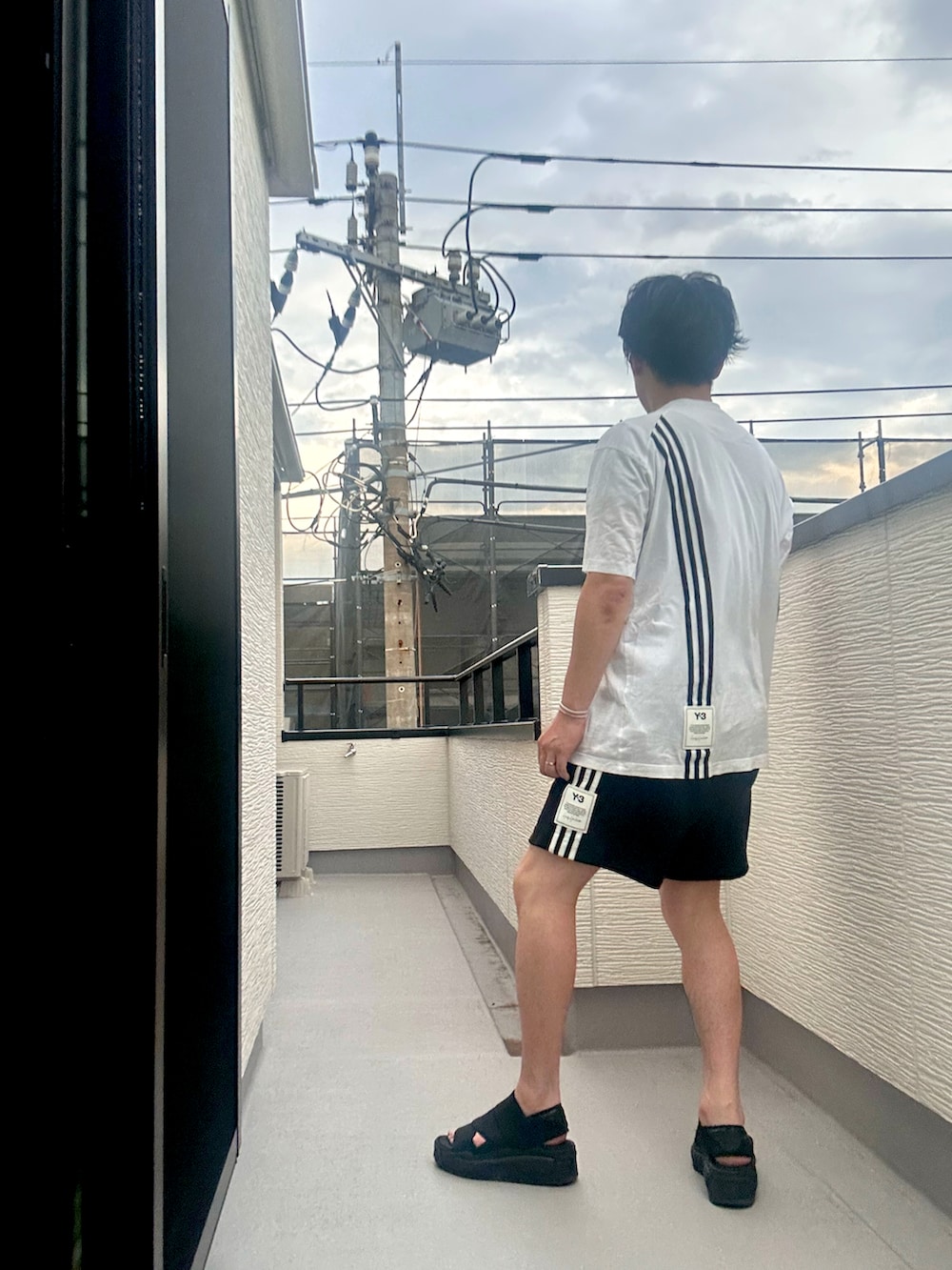 ホワイト系のTシャツ/カットソー、ブラック系のその他パンツ、ブラック系のサンダルを着用したメンズの夏コーディネートの3枚目の写真