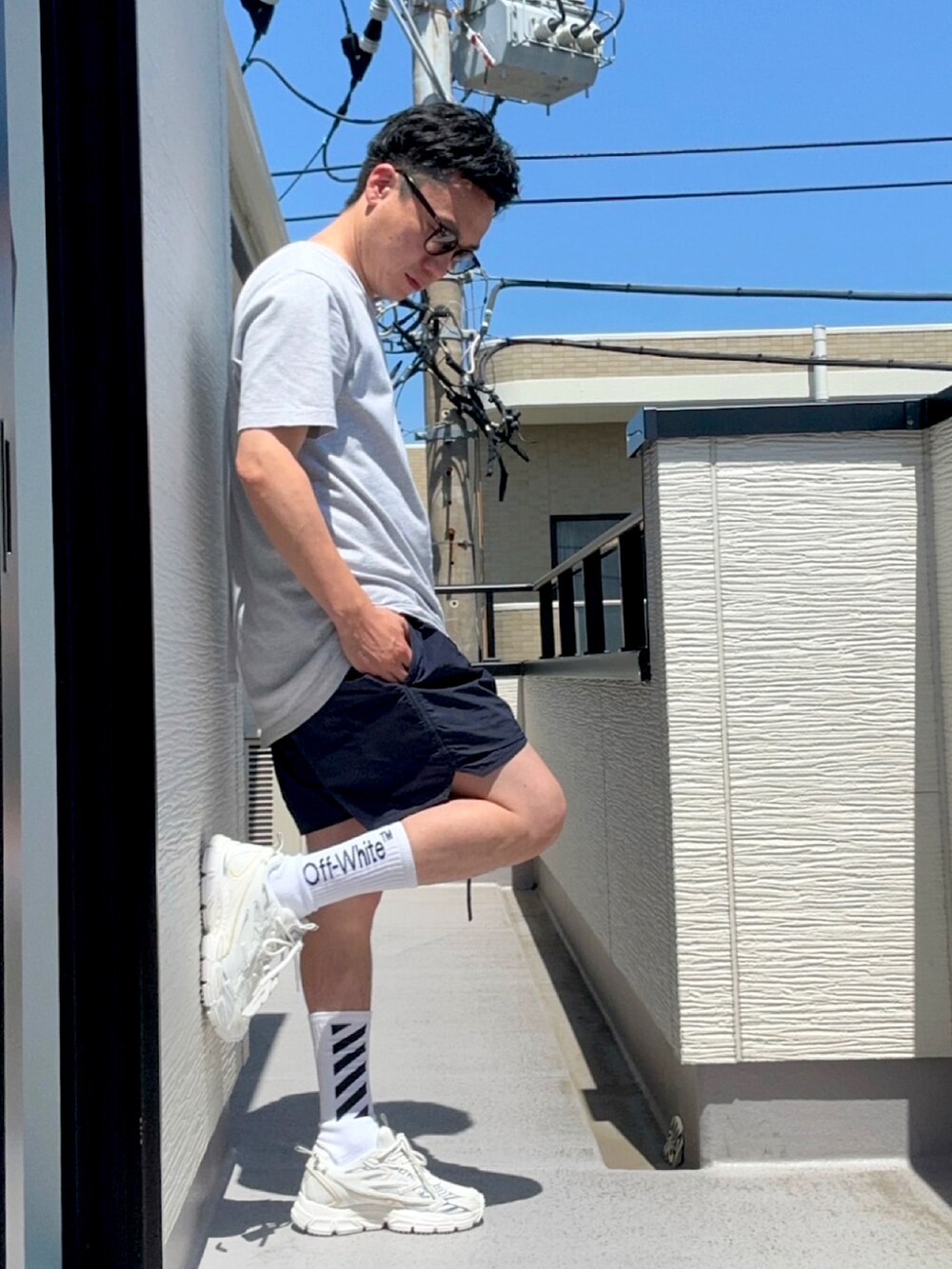 グレー系のTシャツ/カットソー、ブルー系のパンツ、ホワイト系のスニーカーを着用したメンズの夏コーディネートの3枚目の写真