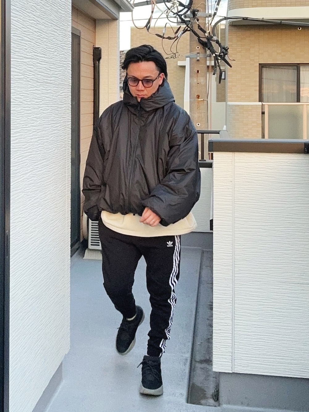 ブラック系のジャケット/アウター、ブラック系のスウェットパンツ、ブラック系のスニーカーを着用したメンズの冬コーディネートの2枚目の写真