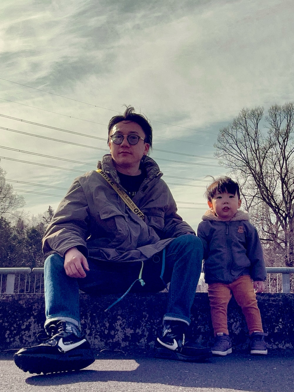 ブラック系のTシャツ/カットソー、ブルー系のデニムパンツ、ブラック系のショルダーバッグを着用したメンズの春コーディネートの5枚目の写真