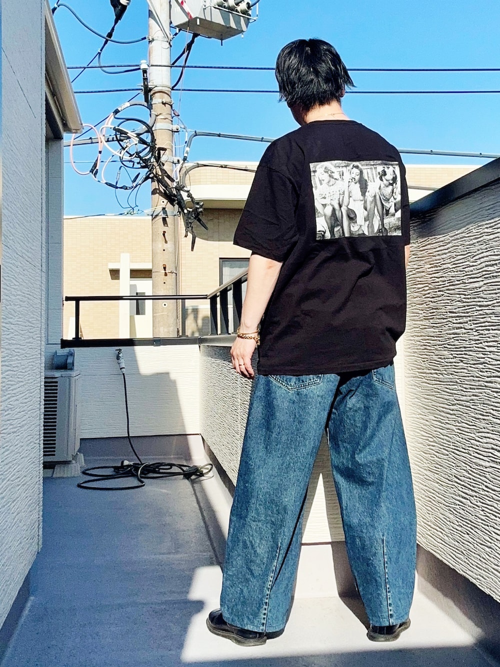 ブラック系のTシャツ/カットソー、ブルー系のデニムパンツ、ブラック系のブーツを着用したメンズの春コーディネートの3枚目の写真
