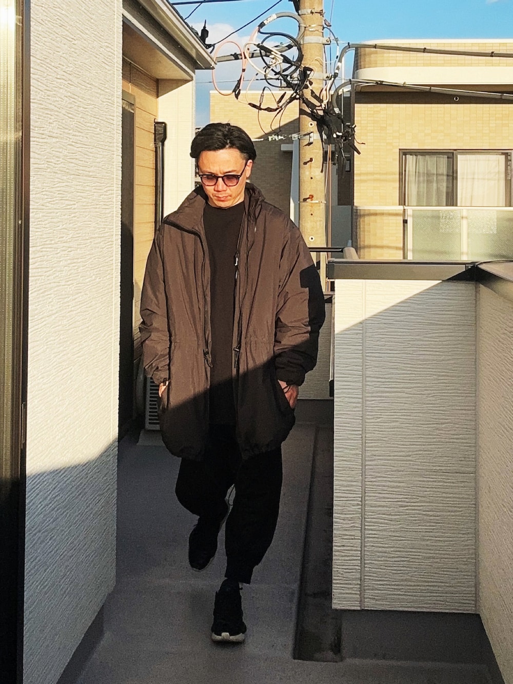 ブラック系のスウェット、ブラック系のその他アウター、ブラック系のスニーカーを着用したメンズの冬コーディネートの2枚目の写真