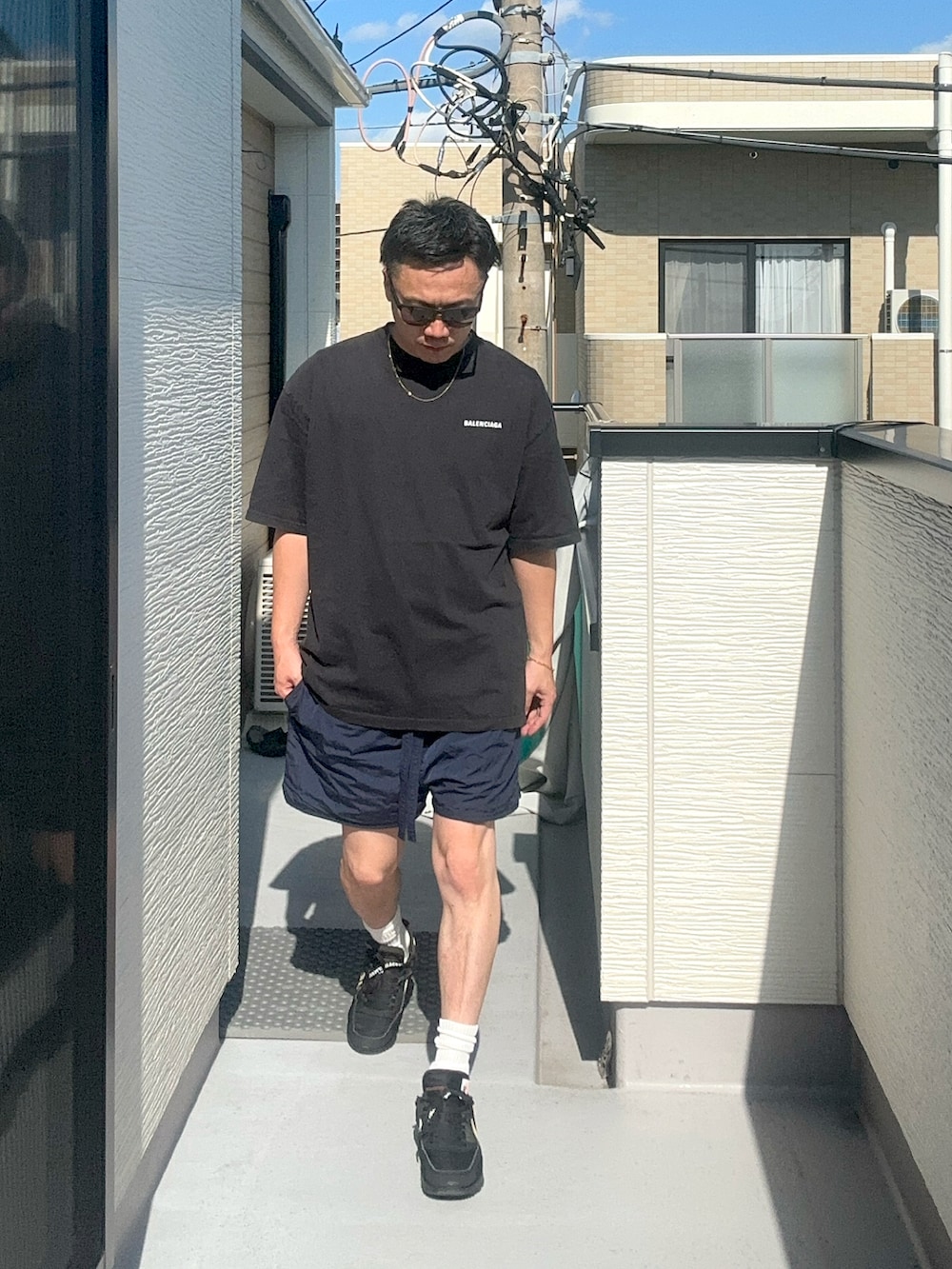 ブラック系のTシャツ/カットソー、ブルー系のパンツ、ブラック系のスニーカーを着用したメンズの秋コーディネートの3枚目の写真