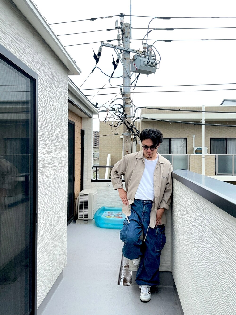 ホワイト系のTシャツ/カットソー、ベージュ系のブルゾン、ブルー系のカーゴパンツを着用したメンズの秋コーディネートの2枚目の写真