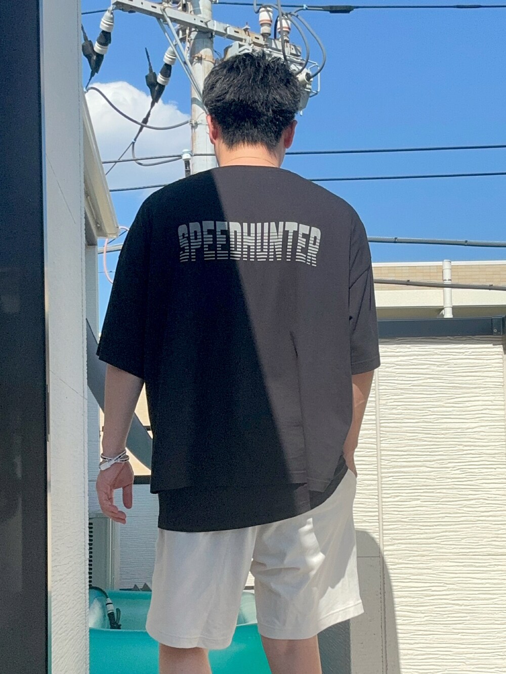 ブラック系のTシャツ/カットソー、ホワイト系のパンツ、ブラック系のシューズを着用したメンズの夏コーディネートの5枚目の写真