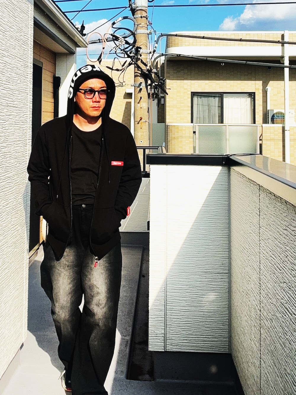 ブラック系のTシャツ/カットソー、ブラック系のパーカー、ブラック系のデニムパンツを着用したメンズの秋コーディネートの3枚目の写真