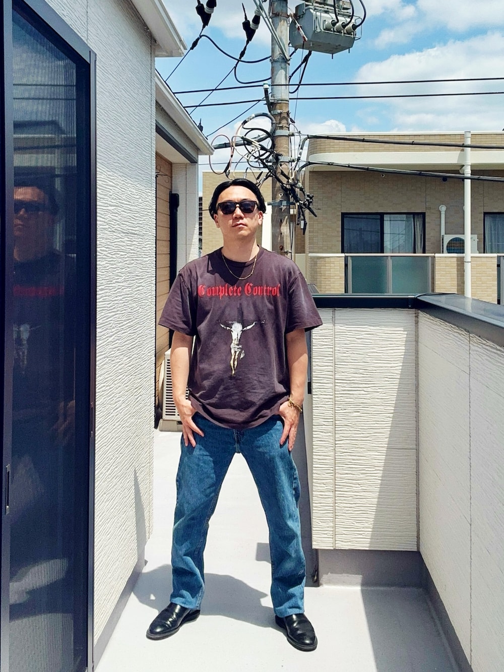 ブルー系のデニムパンツ、ブラック系のTシャツ/カットソー、ブラック系のブーツを着用したメンズの春コーディネートの3枚目の写真