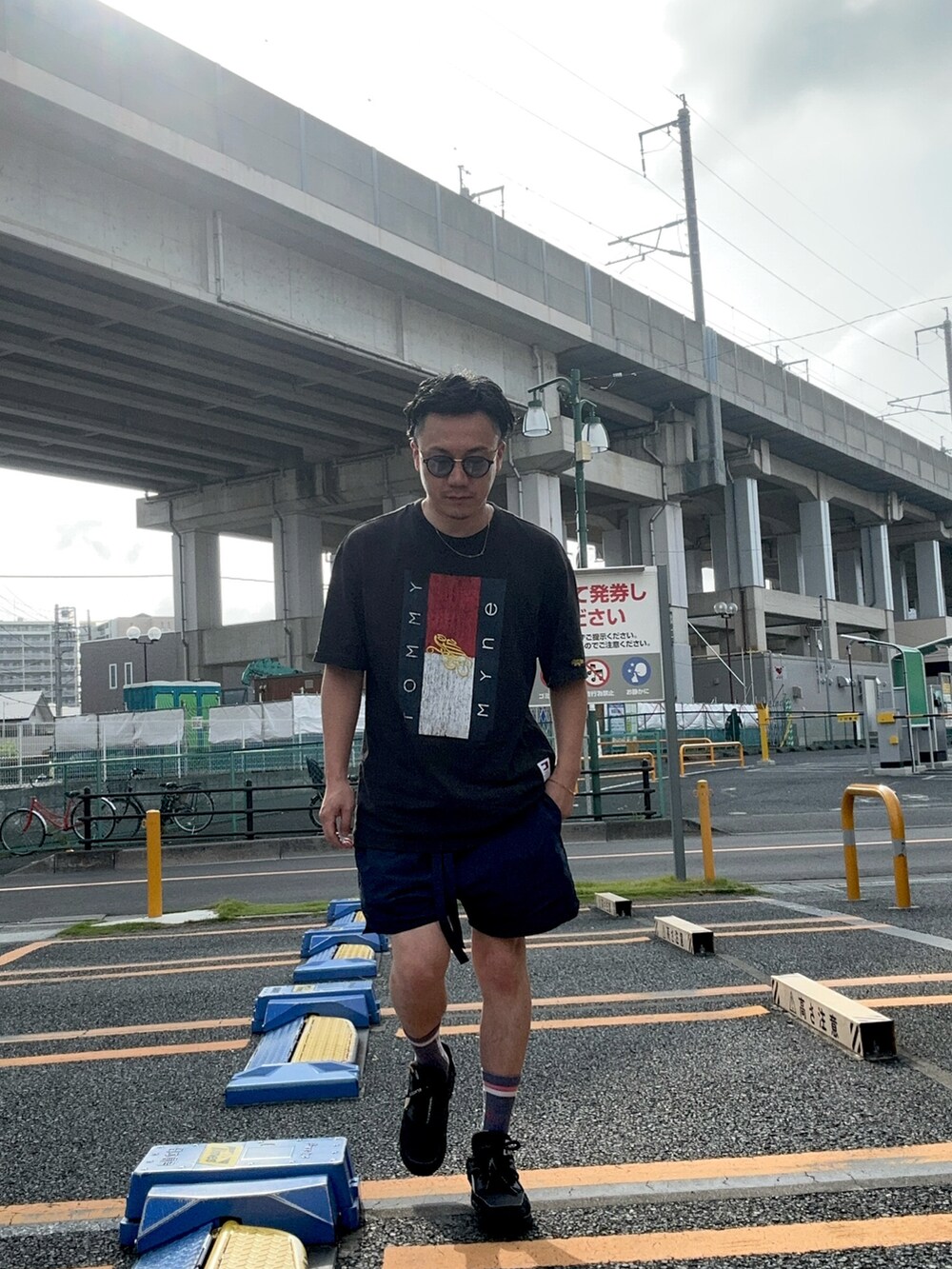 ブラック系のTシャツ/カットソー、ブルー系のパンツ、ブラック系のスニーカーを着用したメンズの夏コーディネートの2枚目の写真