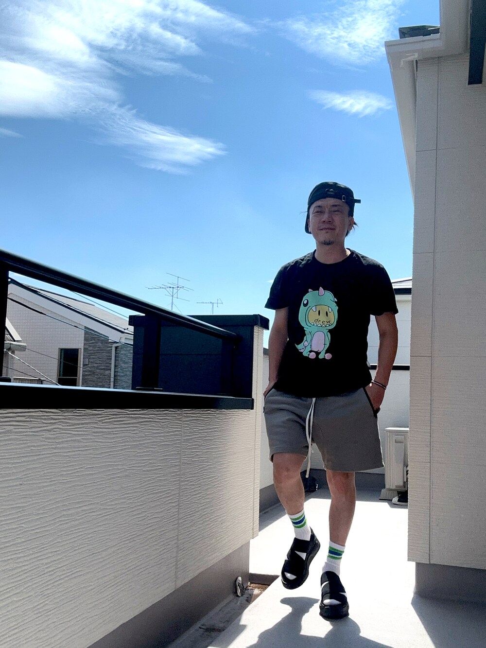 ブラック系のTシャツ/カットソー、グレー系のスウェットパンツ、ブラック系のサンダルを着用したメンズの夏コーディネートの4枚目の写真