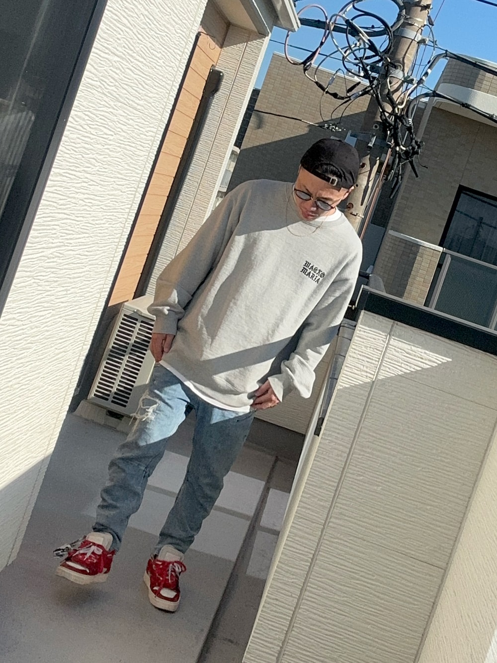 ブルー系のデニムパンツ、グレー系のスウェット、レッド系のシューズを着用したメンズの冬コーディネートの2枚目の写真