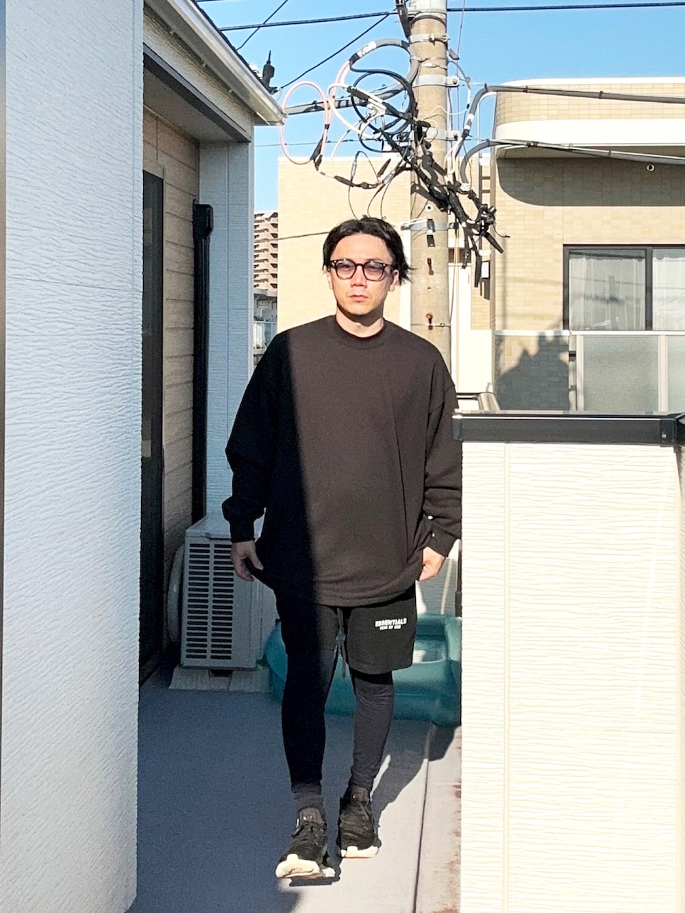 ブラック系のスウェットパンツ、ブラック系のスニーカー、ブラック系のスウェットを着用したメンズの秋コーディネートの3枚目の写真