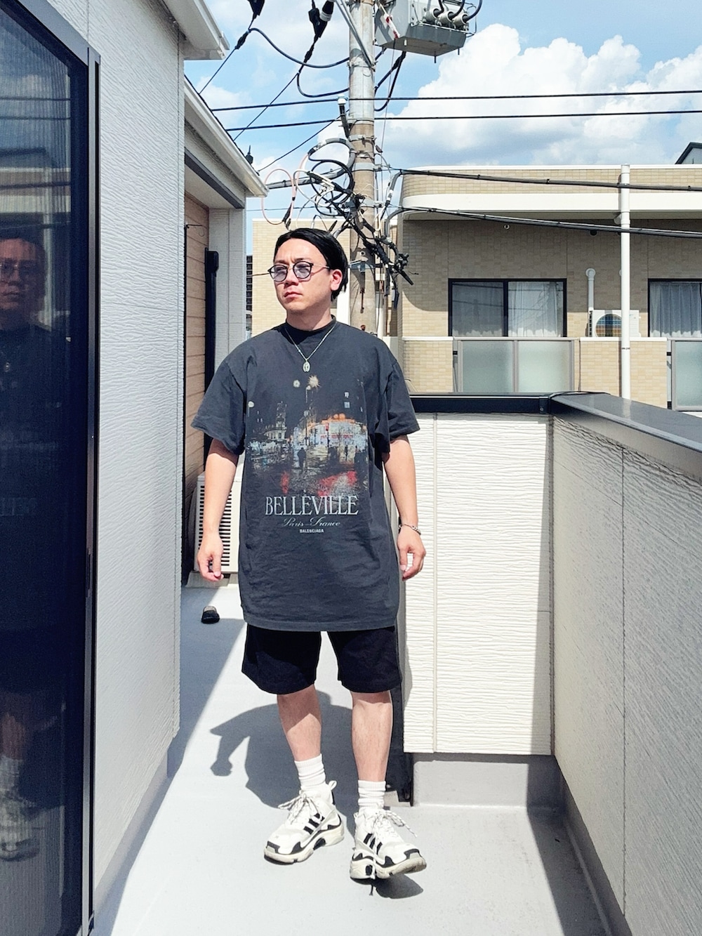ブラック系のTシャツ/カットソー、ブラック系のパンツ、ホワイト系のシューズを着用したメンズの夏コーディネートの3枚目の写真