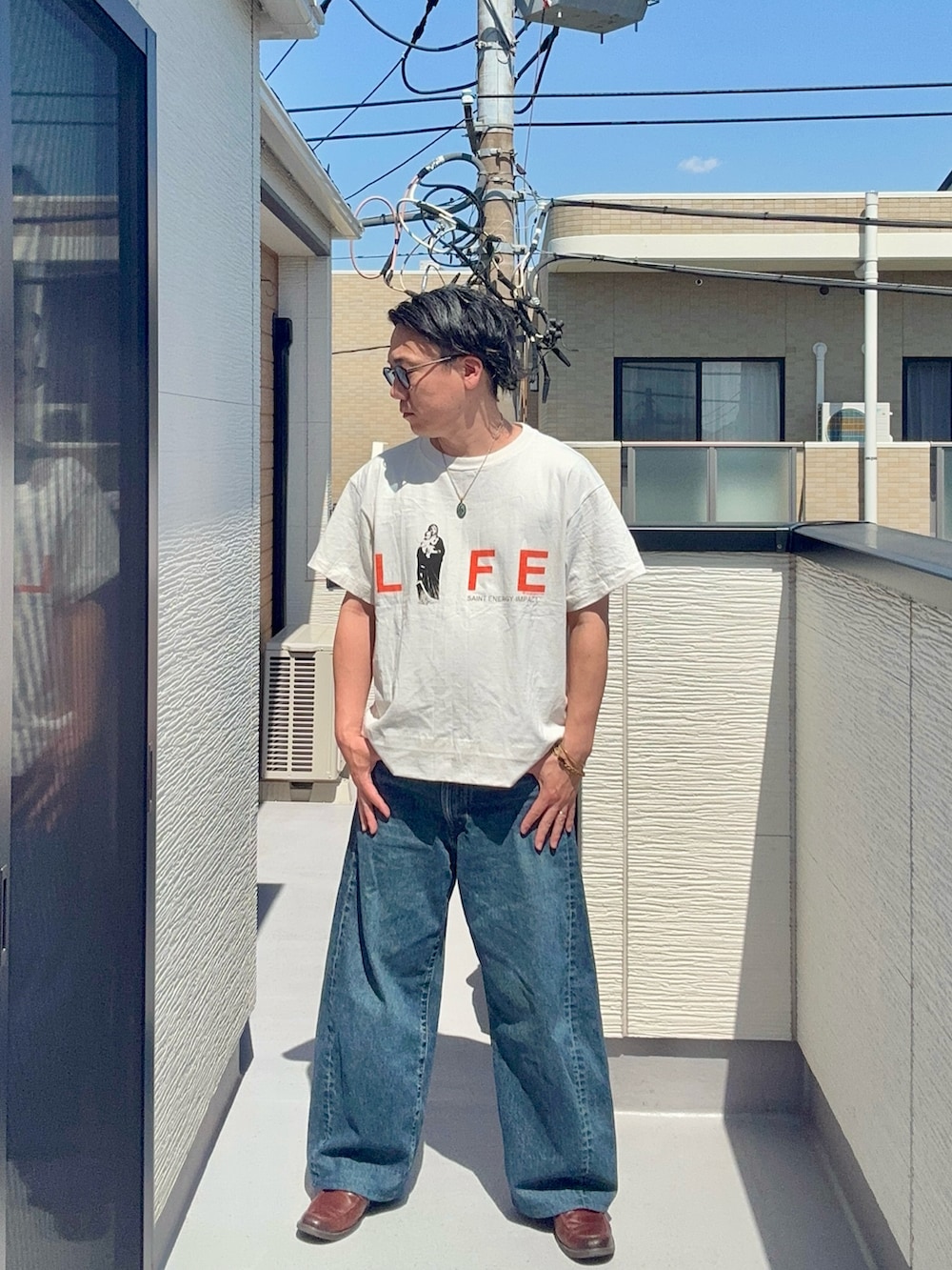 ホワイト系のTシャツ/カットソー、ブルー系のデニムパンツ、ブラウン系のローファーを着用したメンズの春コーディネートの2枚目の写真