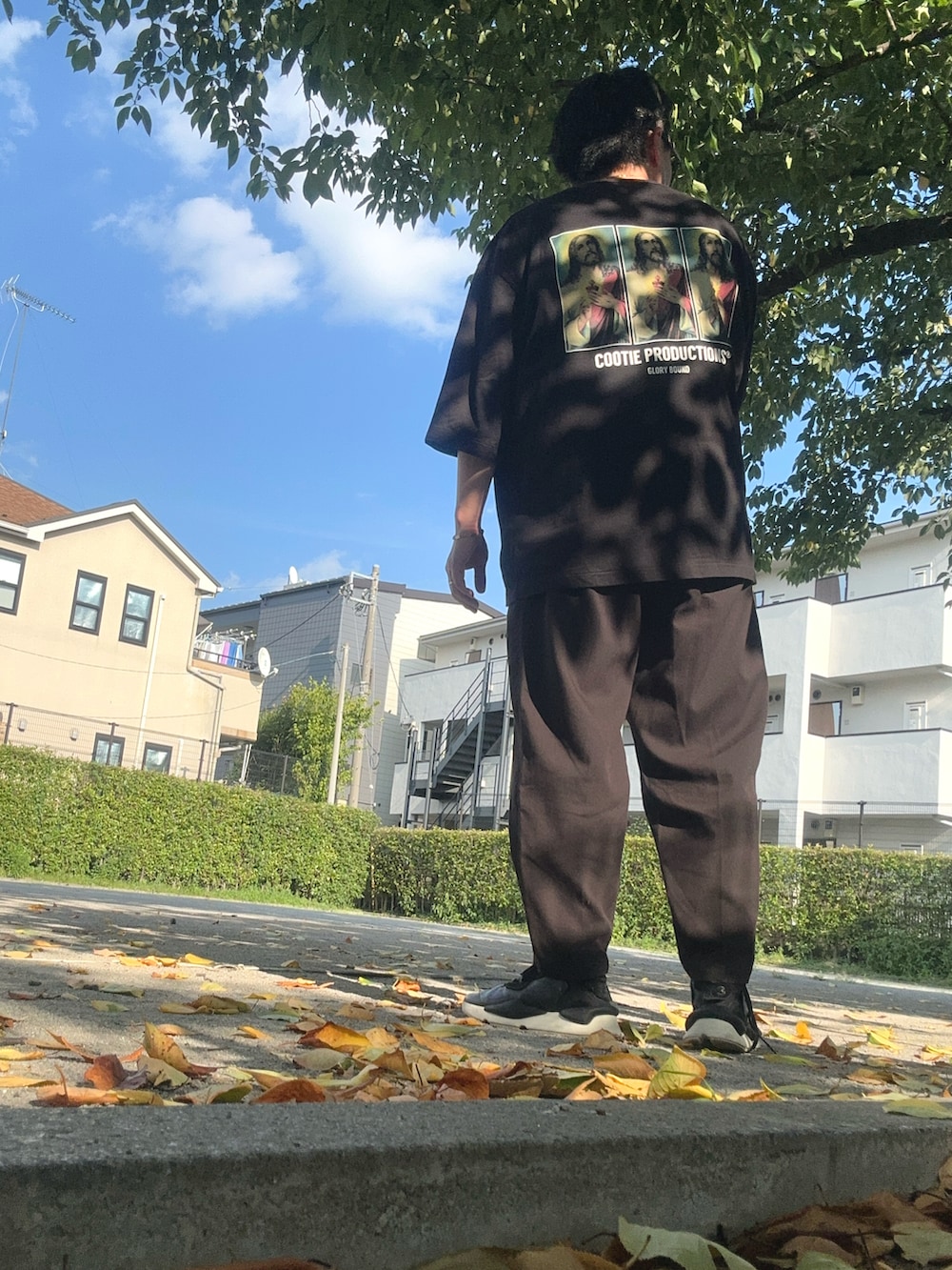 グレー系のTシャツ/カットソー、ブラック系のスニーカー、ブラック系のスラックスを着用したメンズの夏コーディネートの5枚目の写真