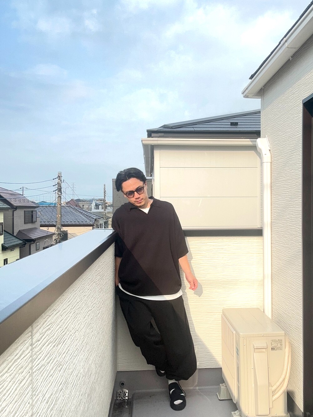 ブラック系のポロシャツ、ブラック系のスウェットパンツ、ブラック系のサンダルを着用したメンズの夏コーディネートの5枚目の写真