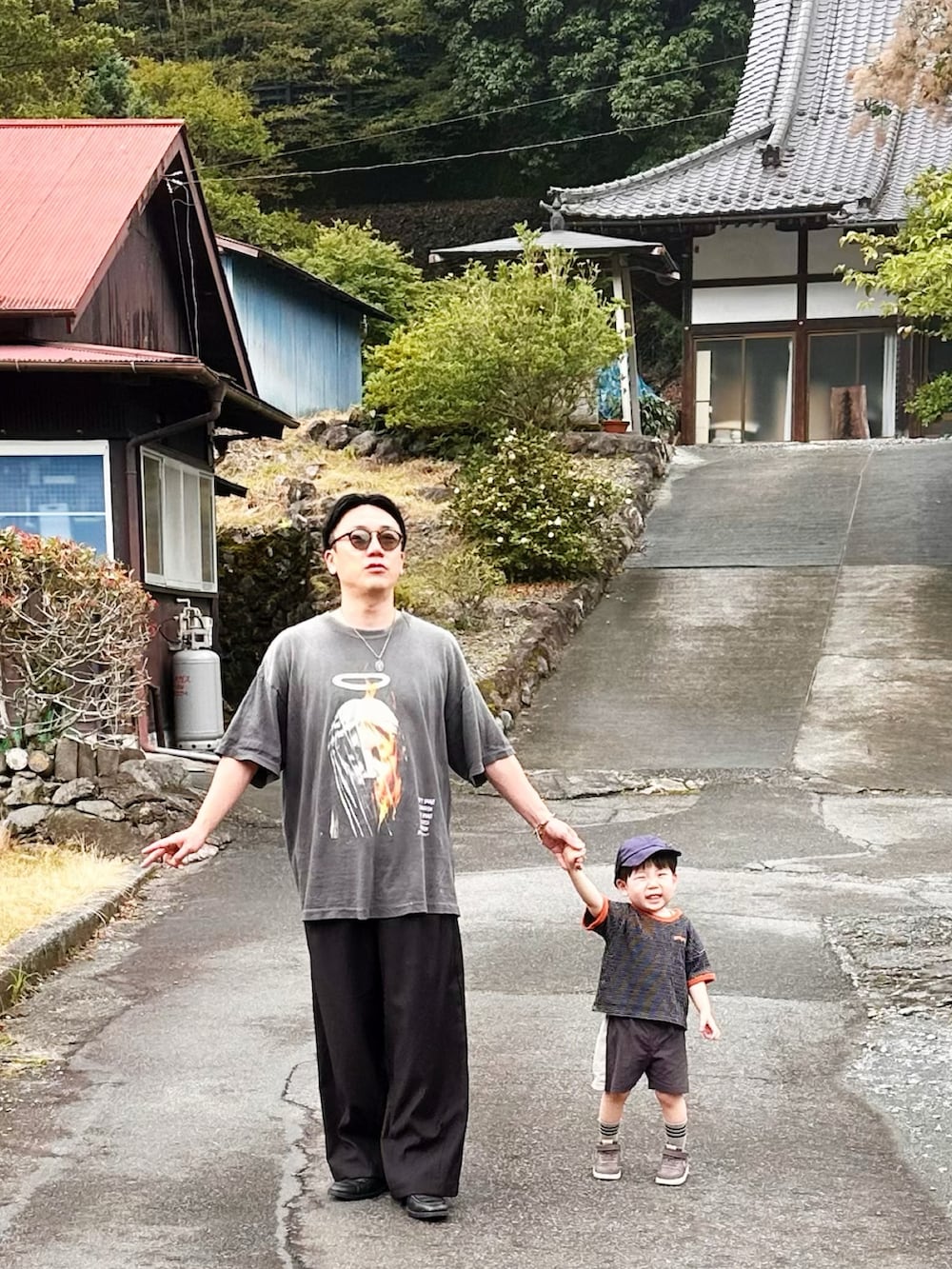 ブラック系のスラックス、ブラック系のローファー、ブラック系のTシャツ/カットソーを着用したメンズの夏コーディネートの4枚目の写真