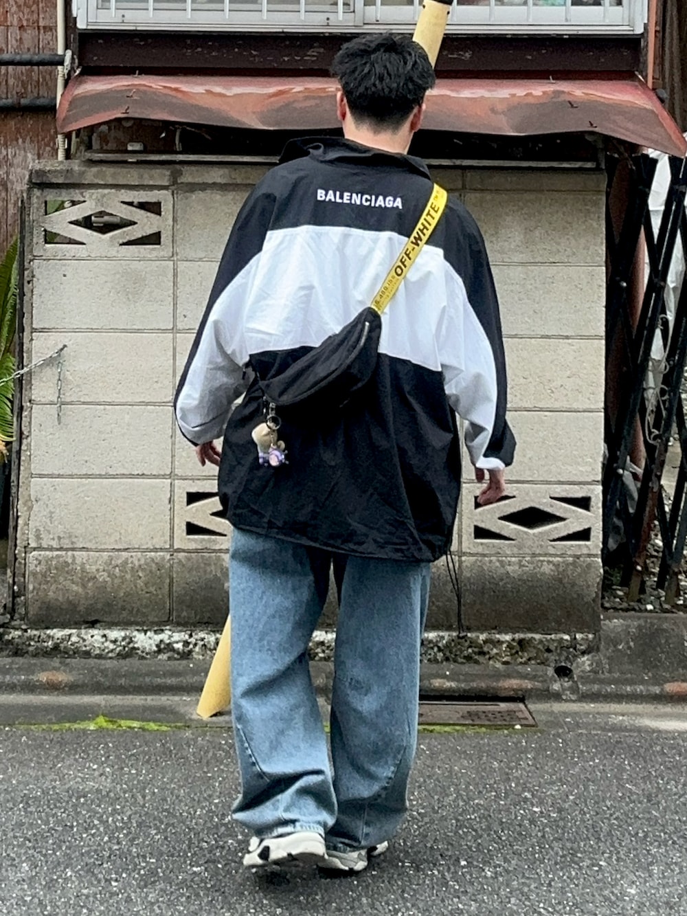 ブルー系のデニムパンツ、ブラック系のショルダーバッグ、ホワイト系のTシャツ/カットソーを着用したメンズの秋コーディネートの4枚目の写真