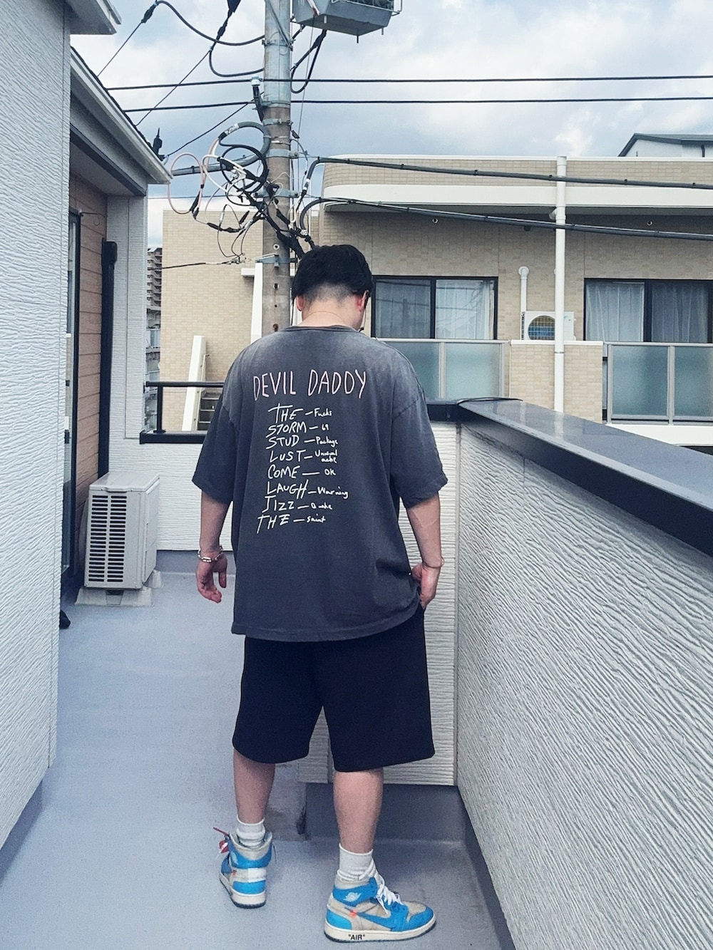 ブラック系のTシャツ/カットソー、ブラック系のスウェットパンツ、ブルー系のスニーカーを着用したメンズの夏コーディネートの2枚目の写真