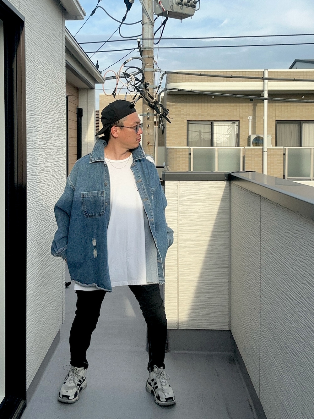 ホワイト系のTシャツ/カットソー、ブルー系のデニムジャケット、ブラック系のデニムパンツを着用したメンズの秋コーディネートの3枚目の写真