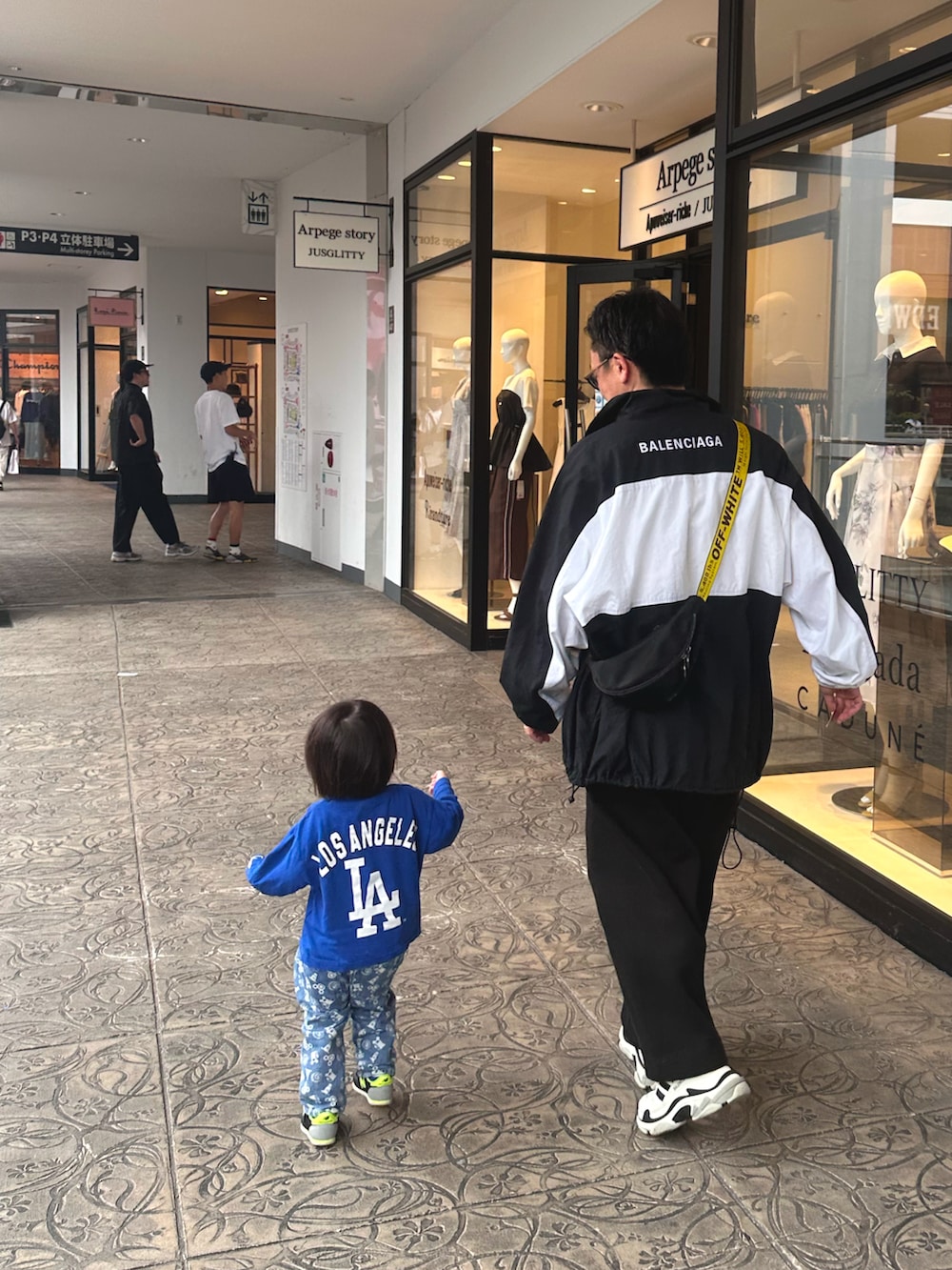 ブラック系のスウェットパンツ、ブラック系のショルダーバッグ、ブラック系のスニーカーを着用したメンズの秋コーディネートの3枚目の写真