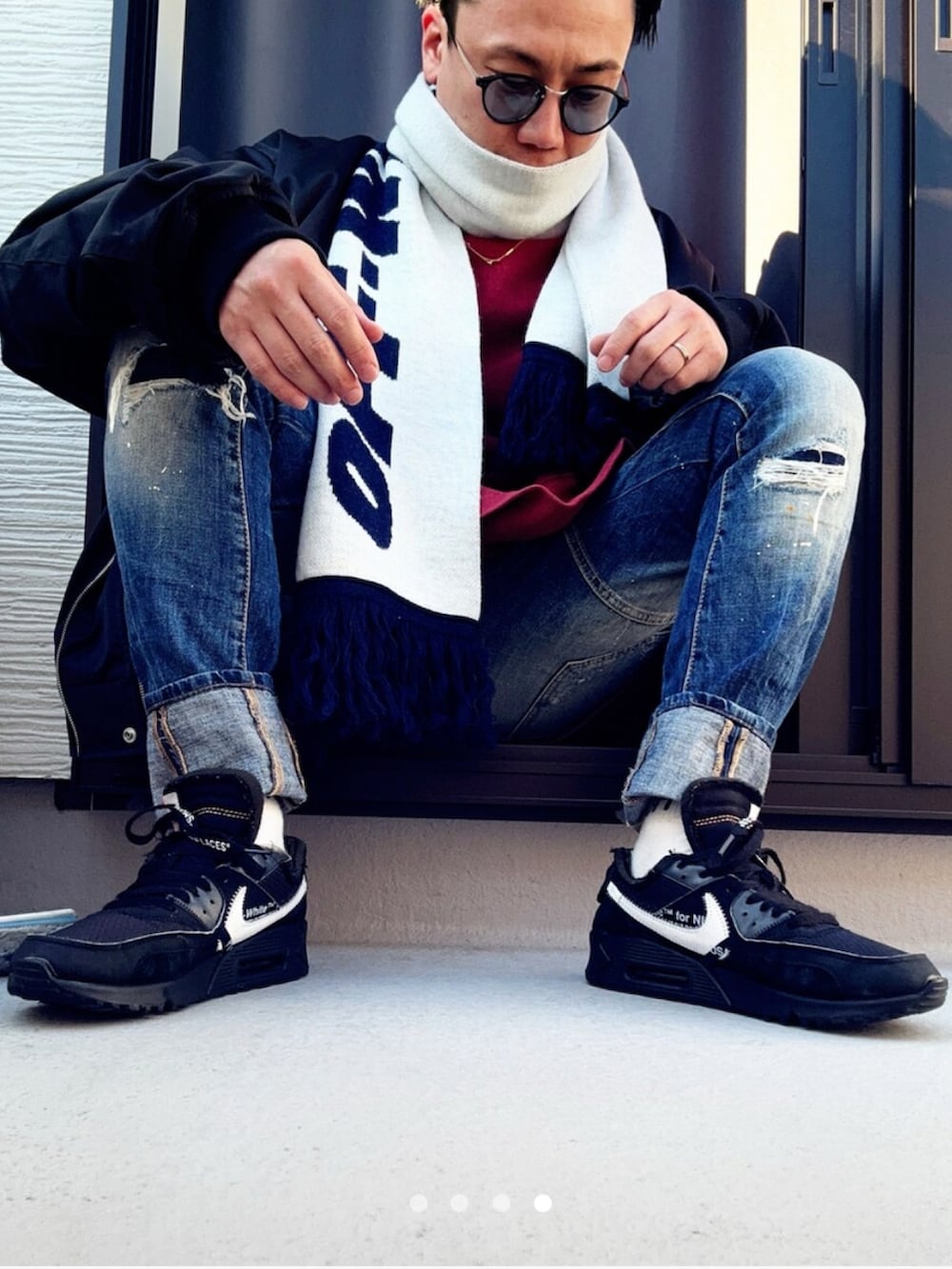 レッド系のスウェット、ブラック系のMA-1、ブルー系のデニムパンツを着用したメンズの冬コーディネートの4枚目の写真