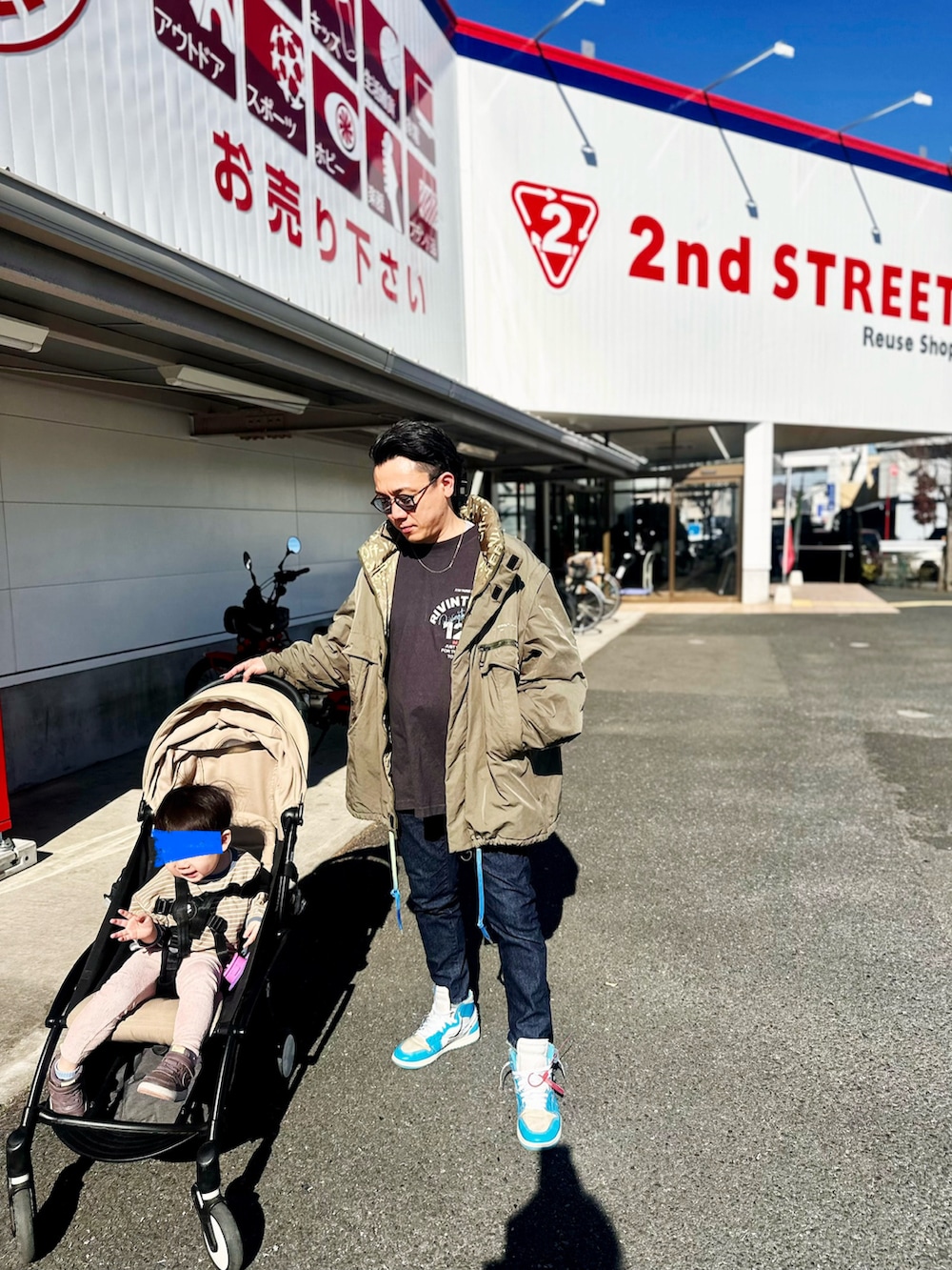 ブラック系のTシャツ/カットソー、グリーン系のミリタリージャケット、ブルー系のデニムパンツを着用したメンズの冬コーディネートの4枚目の写真