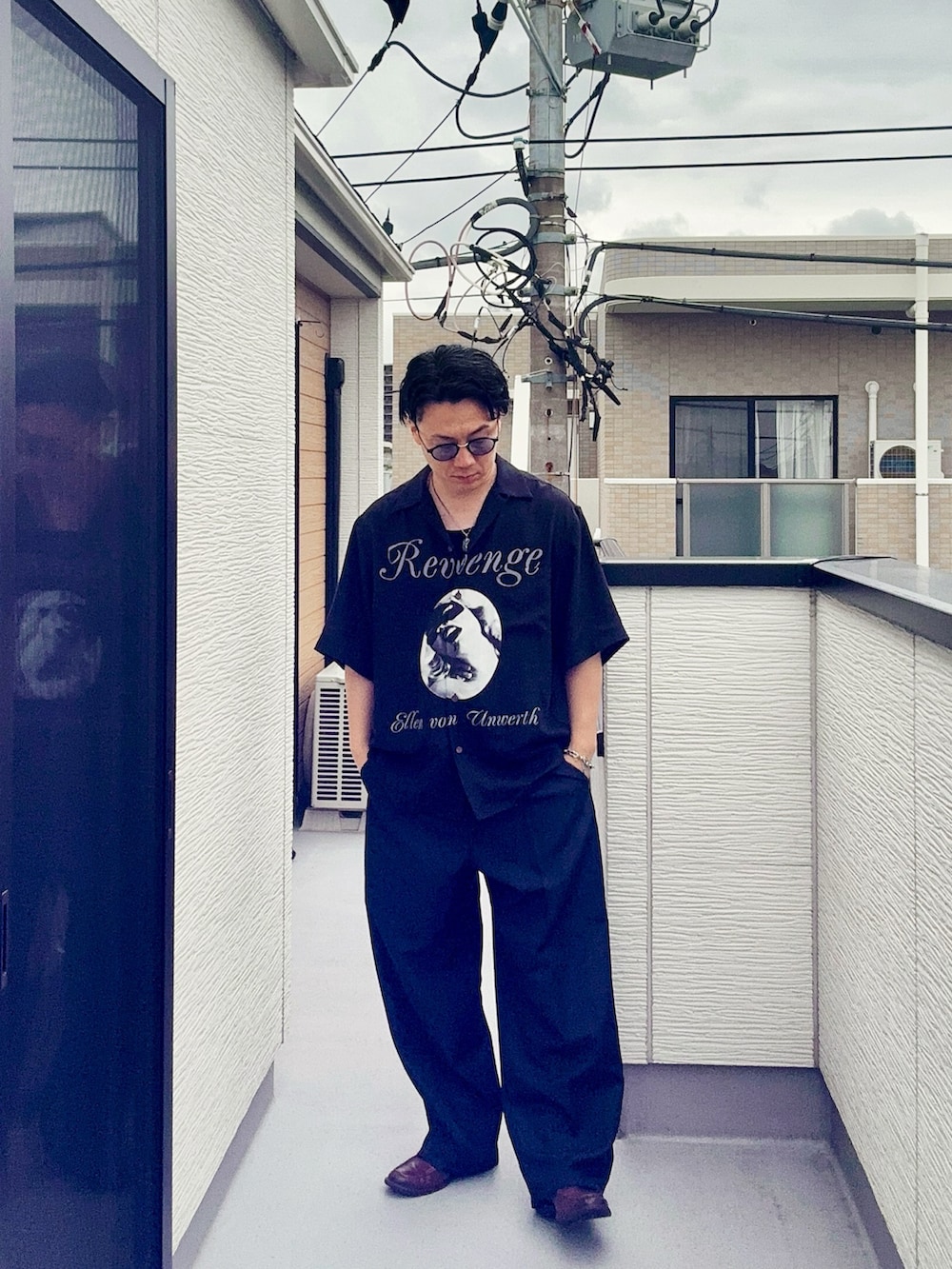 ブルー系のスラックス、ブラック系のシャツ/ブラウス、ブラウン系のローファーを着用したメンズの夏コーディネートの2枚目の写真