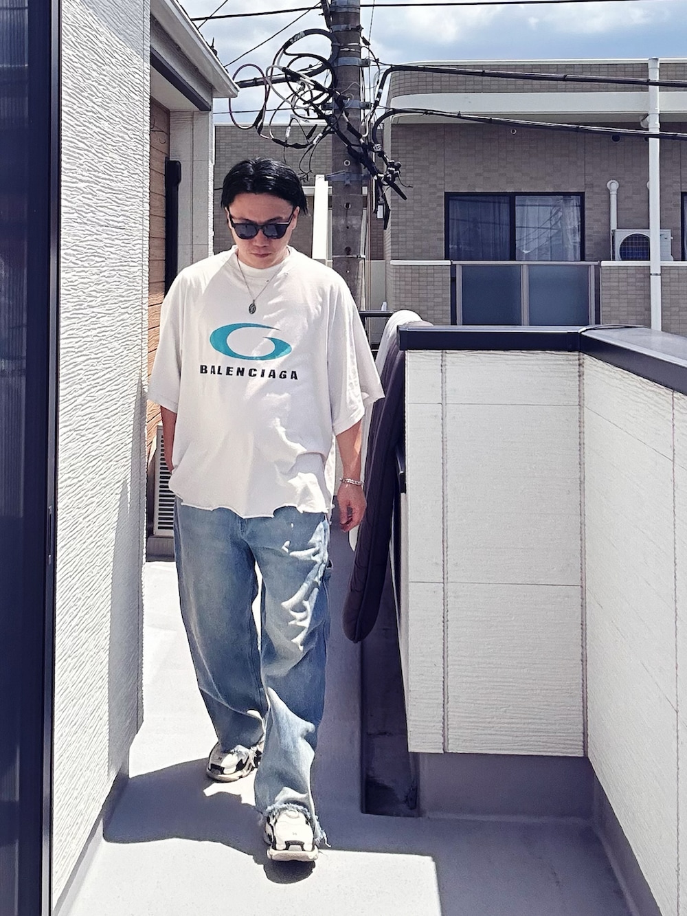 ブルー系のデニムパンツ、ホワイト系のTシャツ/カットソー、ホワイト系のシューズを着用したメンズの夏コーディネートの2枚目の写真