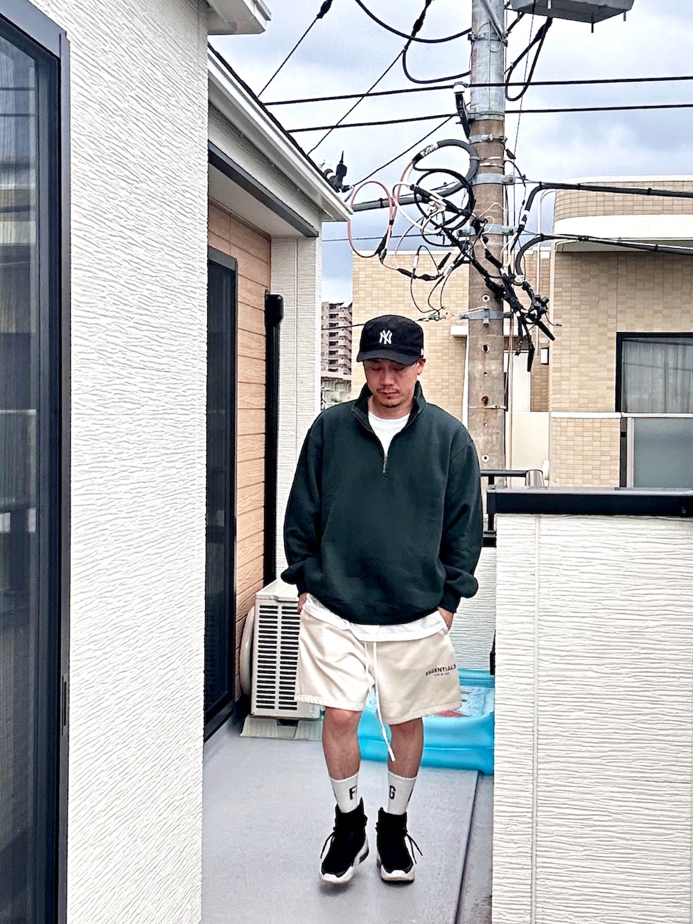 グリーン系のスウェット、ホワイト系のスウェットパンツ、ブラック系のスニーカーを着用したメンズの秋コーディネートの2枚目の写真