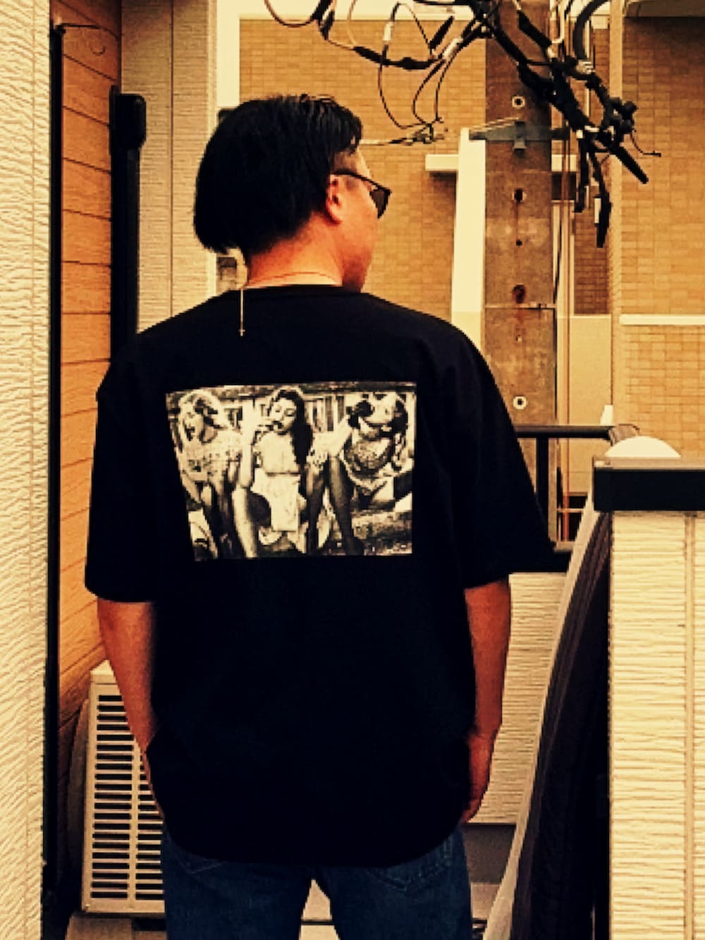 ブルー系のデニムパンツ、ブラック系のTシャツ/カットソー、ブラック系のブーツを着用したメンズの春コーディネートの2枚目の写真