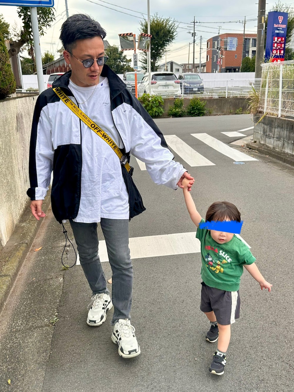 グレー系のデニムパンツ、ブラック系のショルダーバッグ、ブラック系のスニーカーを着用したメンズの秋コーディネートの2枚目の写真