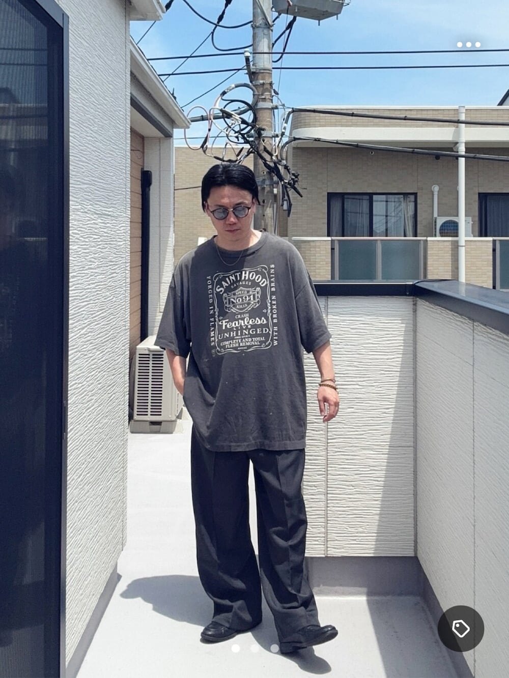 グレー系のスラックス、ブラック系のローファー、ブラック系のTシャツ/カットソーを着用したメンズの夏コーディネートの2枚目の写真