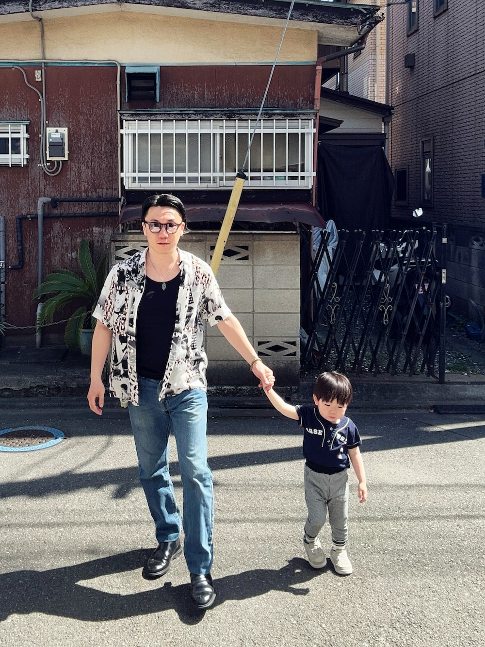 ブルー系のデニムパンツ、ブラック系のタンクトップ、ホワイト系のシャツ/ブラウスを着用したメンズの春コーディネートの2枚目の写真