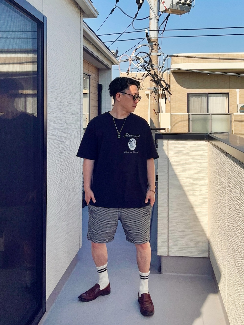 ブラック系のTシャツ/カットソー、ブラック系のパンツ、ブラウン系のローファーを着用したメンズの春コーディネートの3枚目の写真
