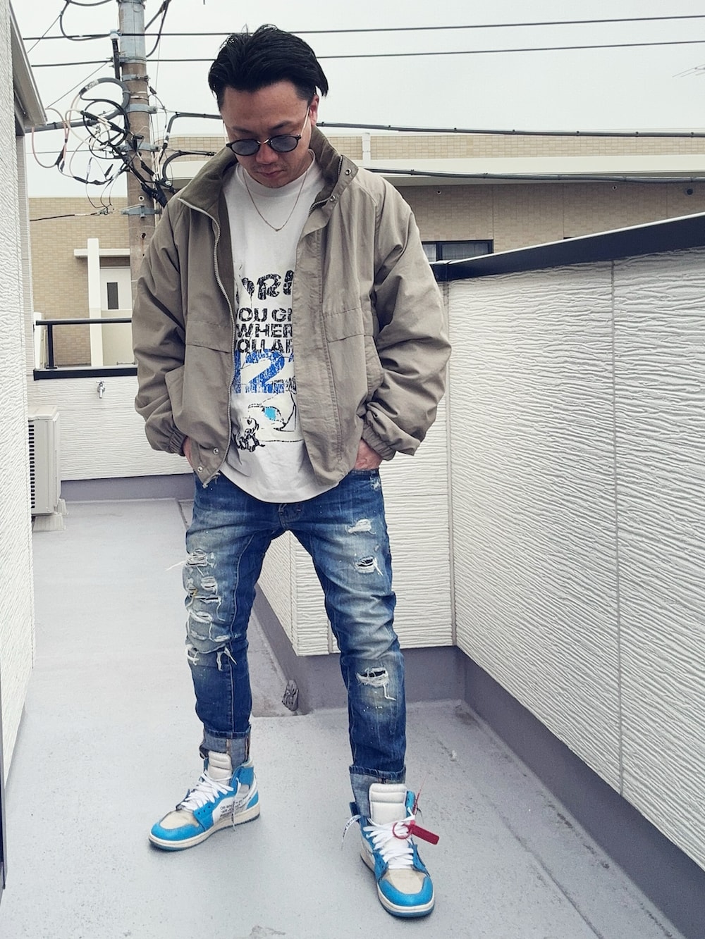 ベージュ系のブルゾン、ブルー系のデニムパンツ、ホワイト系のTシャツ/カットソーを着用したメンズの冬コーディネートの3枚目の写真