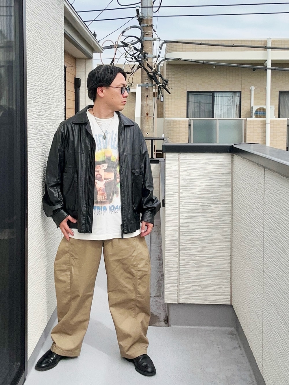 ブラック系のブルゾン、ホワイト系のTシャツ/カットソー、ベージュ系のパンツを着用したメンズの秋コーディネートの3枚目の写真