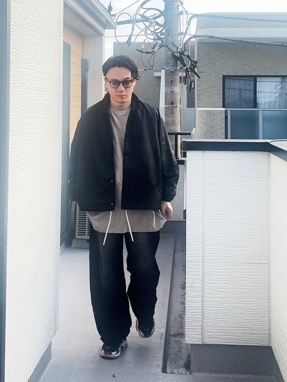 グレー系のTシャツ/カットソー、ブラック系のナイロンジャケット、ブラック系のデニムパンツを着用したメンズの秋コーディネートの2枚目の写真