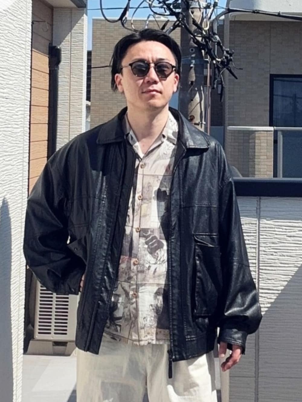 ブラック系のブルゾン、ベージュ系のシャツ/ブラウス、ホワイト系のチノパンツを着用したメンズの春コーディネートの2枚目の写真