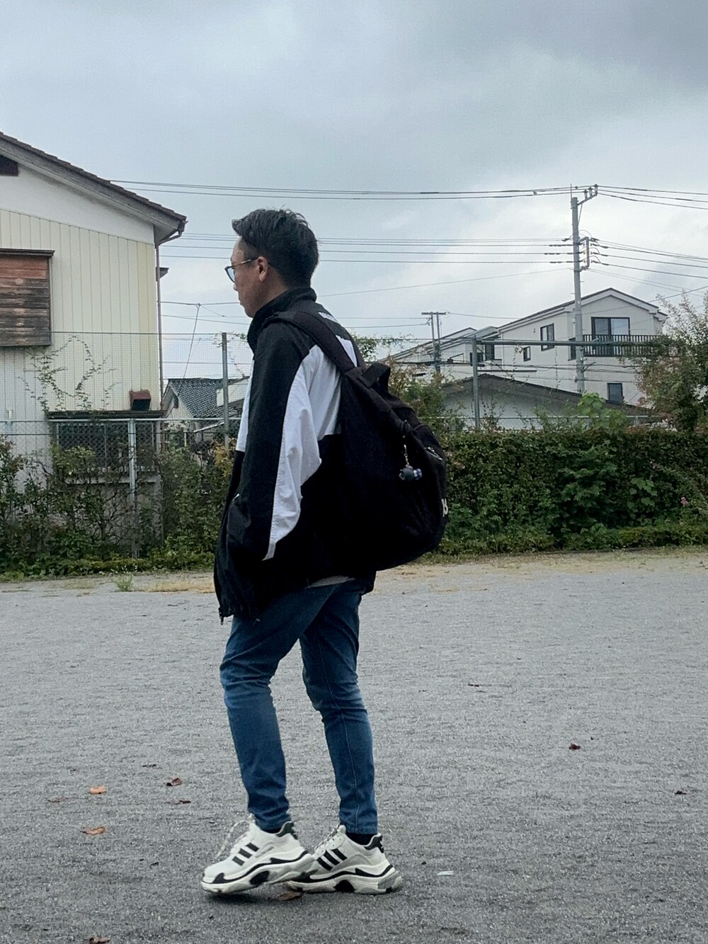 ブルー系のデニムパンツ、グレー系のTシャツ/カットソー、ブラック系のバックパック/リュックを着用したメンズの秋コーディネートの4枚目の写真