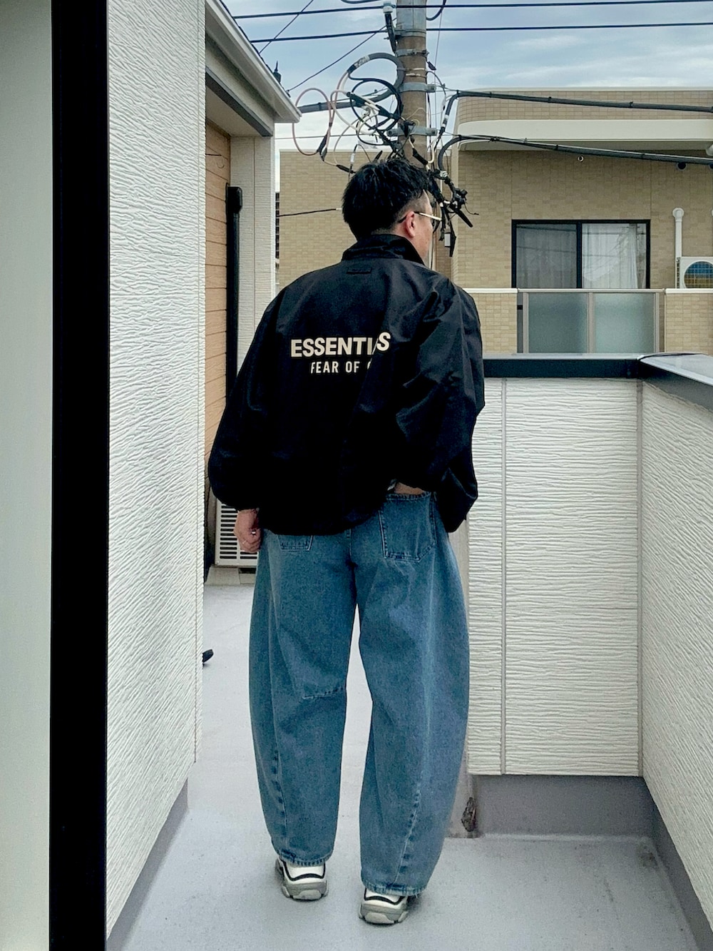 ブルー系のデニムパンツ、ブラック系のナイロンジャケット、ホワイト系のTシャツ/カットソーを着用したメンズの秋コーディネートの4枚目の写真