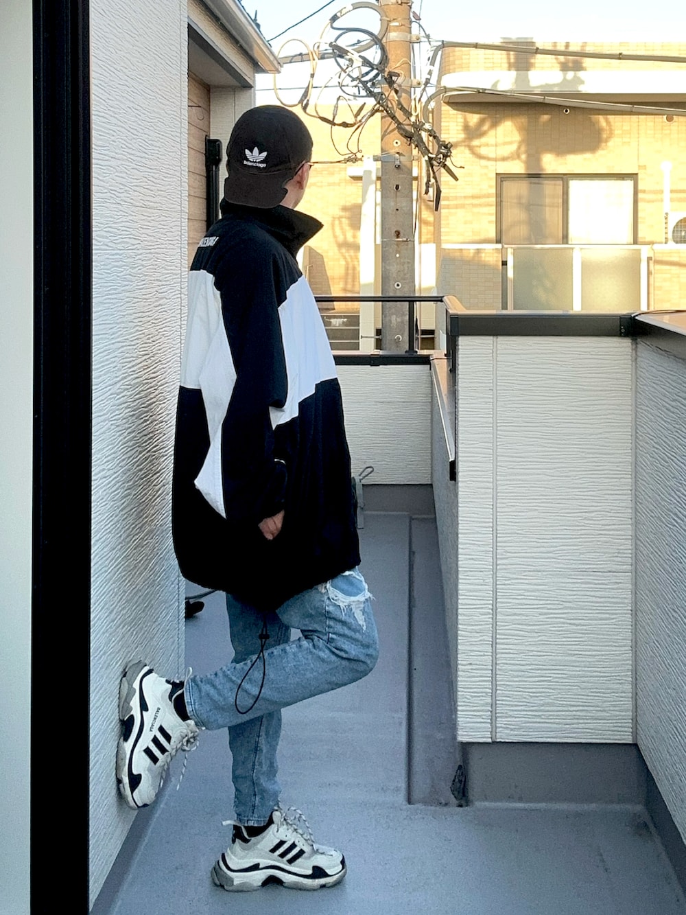 ブルー系のデニムパンツ、ホワイト系のトップス、ブラック系のナイロンジャケットを着用したメンズの秋コーディネートの3枚目の写真