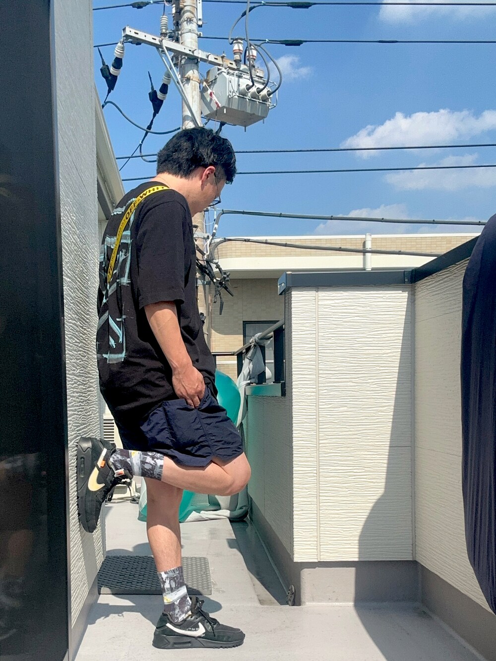 ブラック系のショルダーバッグ、ブラック系のTシャツ/カットソー、ブルー系のパンツを着用したメンズの夏コーディネートの3枚目の写真