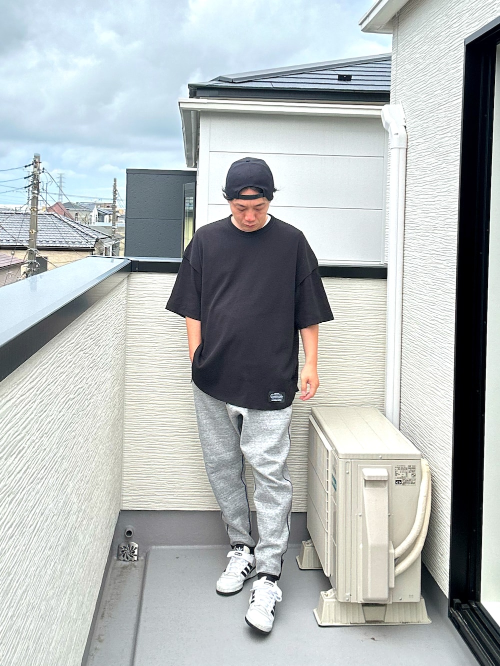 ブラック系のその他トップス、グレー系のパンツ、ホワイト系のスニーカーを着用したメンズの夏コーディネートの4枚目の写真