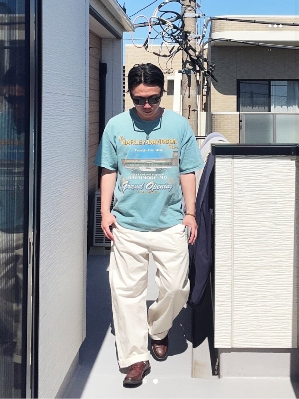 ブルー系のTシャツ/カットソー、ホワイト系のチノパンツ、ブラウン系のローファーを着用したメンズの春コーディネートの2枚目の写真