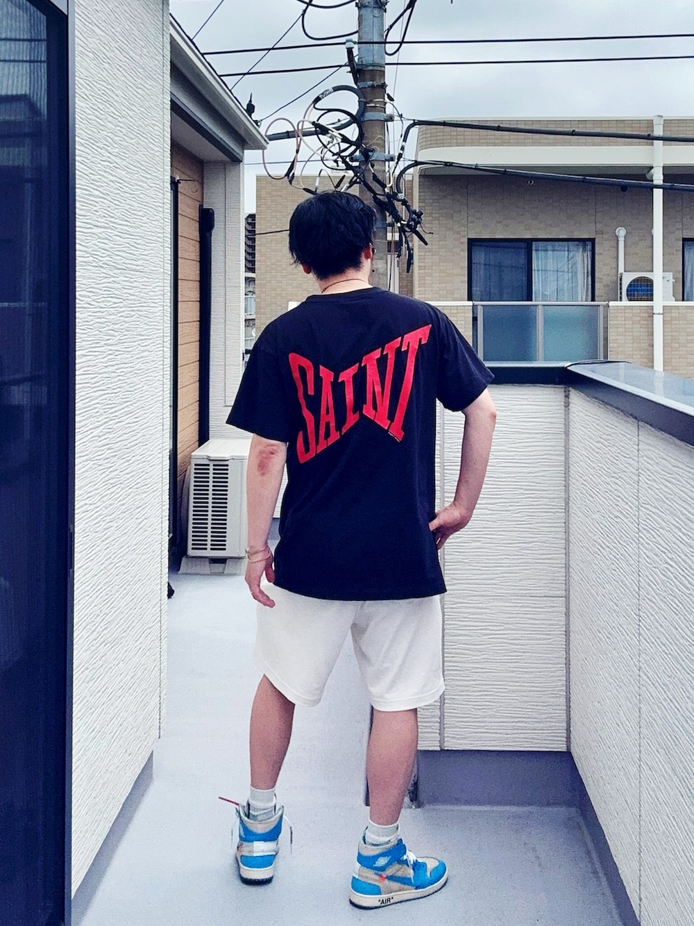 ブラック系のTシャツ/カットソー、ホワイト系のパンツ、ブルー系のスニーカーを着用したメンズの夏コーディネートの3枚目の写真